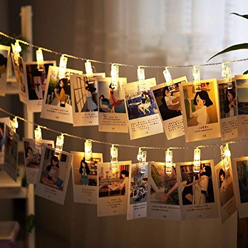 Varal de led com pregadores transparentes encaixados nas luzes, segurando papéis impressos com diversas imagens e legendas.