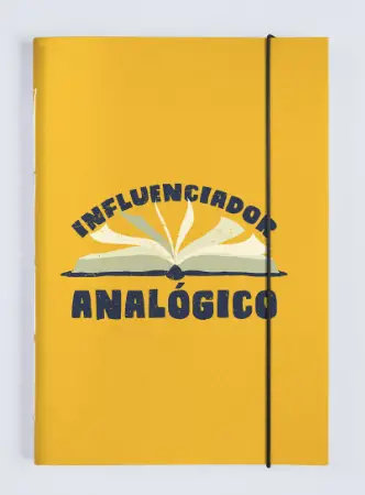 Caderno amarelo pequeno, escrito na capa "influenciador analógico" entre os presentes para professora
