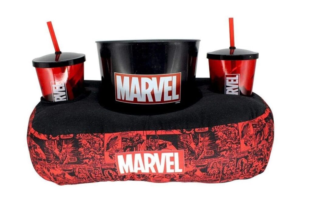 Almofada porta pipoca na cor vermelha e preta, com dois copos com canudo, com estampas dos quadrinhos Marvel. 
