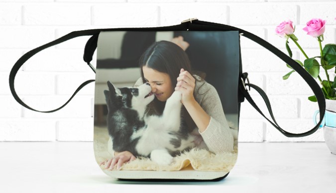 Bolsa lateral com imagem de uma mulher com um cachorro estampada. 